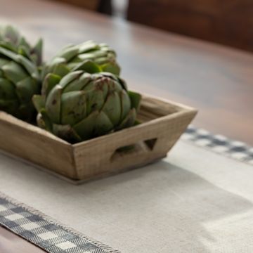 Show details for Buffalo Plaid Mini A wooden bowl filled with Chalk Couture transfers sits on a table adorned with a checkered table runner. The background is slightly blurred, highlighting the transfers as the main focus of the image. The scene is well-lit, giving a fresh and natural feel.