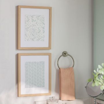 Show details for Four Texture Patterns A bathroom wall features two framed, abstract art pieces with light blue patterns. Below the art, a peach-colored towel hangs neatly on a round, silver towel ring. A small plant and a round mirror are visible on the countertop. The artwork was created using the "Transfer" from Chalk Couture.