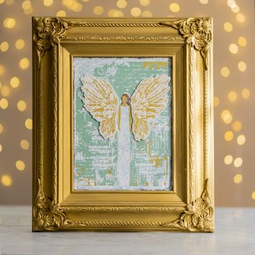 Show details for Painterly Angel A golden ornate frame displays a painted depiction of an angel with outstretched wings on a textured green and white background. The angel is illustrated simply with muted tones. The backdrop features soft, circular light bokeh effects created using the Chalk Couture transfer.