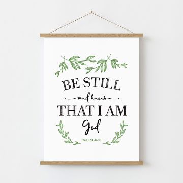Show details for Meadow Paste Single A decorative wall hanging features the quote "Be still and know that I am God. Psalm 46:10" in black text. The quote is surrounded by green botanical illustrations and mounted on a wooden frame. The background is plain white, created using Chalk Couture paste.