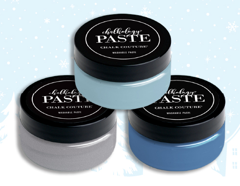 Three jars of chalk couture paste in black, grey, and blue colors set against a winter-themed background with snowflakes.