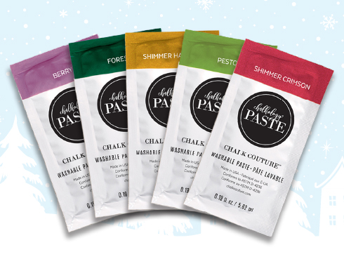Five colorful packets of chalk paste lined up, each labeled "chalk couture washable paste" in various shades including green, yellow, red, and purple, against a snowflake-patterned background.