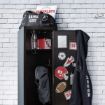 An open sports locker filled with various items, including a backpack, water bottle, and sports bag. The locker is adorned with sports-themed stickers and decals from Chalk Couture featuring the transfer design. A jacket with the name "Logan" hangs on the side. A brick wall serves as the background.