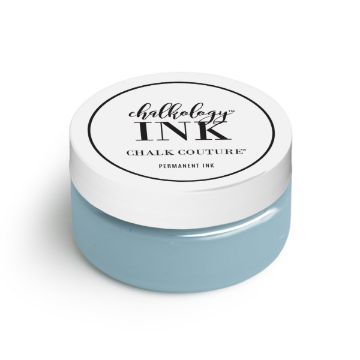 Show details for Ocean Mist Ink A small, round container of ink by Chalk Couture. The container has a white lid with black text that reads "chalkology INK" and "CHALK COUTURE" on it. The jar itself appears to be filled with light blue permanent ink.