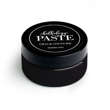 Show details for Shimmer Shadow Paste A small, black cylindrical container labeled "Chalk Couture paste" on the lid. The container has a sleek, modern design and is used for crafting and creating chalk-style art.