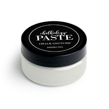 Show details for Shimmer Frost Paste A round, white jar with a black lid labeled "paste" and "Chalk Couture" in white text. The label also mentions "Washable Paste." The container appears to hold white chalk paste for craft or artistic use.