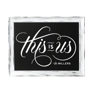Show details for This Is Us Alphabet A framed chalkboard displays the phrase "This is us" in elegant, cursive white lettering. Below, the text "the Millers" is written in smaller print. The frame is white with a distressed, rustic finish.