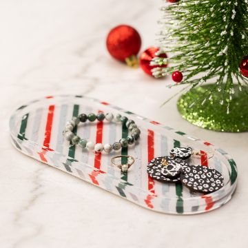 Show details for Resin & Hardener An oval marble tray with green, red, and white streaks on it holds a bead bracelet, a small ring, and a pair of black and white patterned earrings. A small decorated Christmas tree and a red ornament are in the background on a marble surface.
