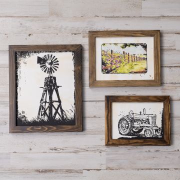 Show details for Tractor Three framed prints on a wooden wall. The top left features a windmill, the top right is a colorful countryside landscape with a fence, and the bottom right depicts a vintage tractor. All frames are wooden with a rustic finish.
