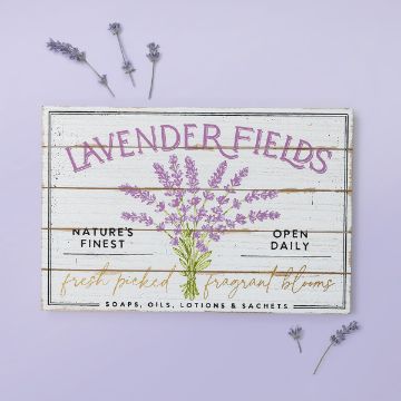 Show details for Lavender Fields A sign reading "Lavender Fields" with illustrations of lavender sprigs. Text includes "Nature's Finest," "Open Daily," "Fresh Picked Fragrant Blooms," and "Soaps, Oils, Lotions & Sachets." Lavender sprigs are scattered on a light purple background.