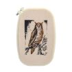 An embroidery hoop with beige fabric displays a detailed stitched image of a brown owl perched on a branch, with a simple black background behind the owl.