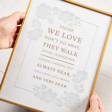 Show details for Those We Love A person holds a framed sign with gold text and floral designs. The sign reads: "Those we love don't go away, they walk beside us everyday. Unseen, unheard, but always near, still loved, still missed and very dear.