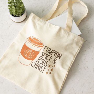 Show details for Pumpkin Spice & Jesus Christ A beige tote bag with an illustration of a coffee cup featuring a pumpkin and the text “Pumpkin Spice & Jesus Christ,” placed on a light surface next to a small potted succulent.