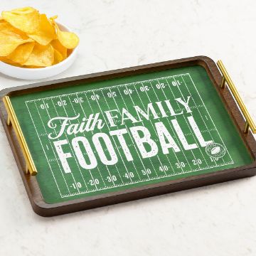 Show details for Faith Family Football A rectangular tray with a football field design and the words "Faith Family Football" written on it, placed on a light surface next to a bowl of potato chips.