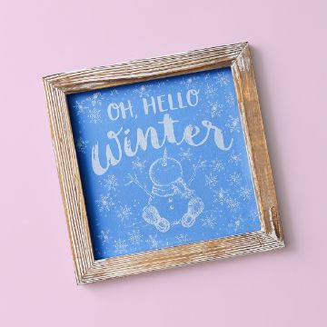 Show details for Hello Winter Snowman A rustic wooden frame with a blue background displays the white text "Oh, Hello Winter" and a simple drawing of a snowman with snowflakes, set against a pink surface.