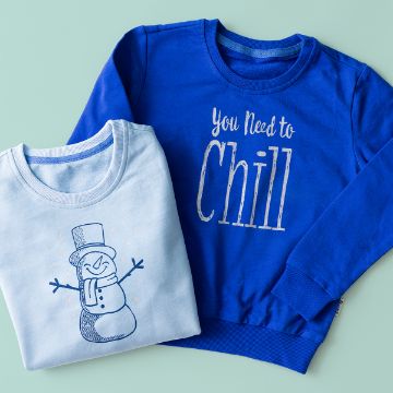 Show details for You Need To Chill Two sweatshirts: one light blue with a snowman illustration, and one blue with the text "You Need to Chill" in white letters. Both are laid flat on a light blue surface.