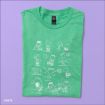 A folded green T-shirt on a lavender background features white line drawings of Peanuts characters playing football, including scenes of Lucy pulling the ball away from Charlie Brown.