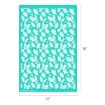A stencil sheet measuring 12 by 18 inches features a repeating pattern of white holly leaves and berries on a teal background.