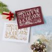 A small gift box, festive pine branch, and bag of gold jingle bells sit beside three "Happy Holidays and a Joyful New Year" greeting cards in red, gold, and silver on a light background.