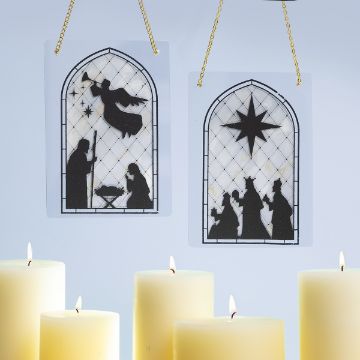 Show details for Stained Glass Scenes Two stained glass-style ornaments with nativity silhouettes hang above lit candles. One shows an angel with Mary, Joseph, and baby Jesus; the other features the three wise men following a star.