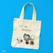 A cream tote bag on a blue background features Snoopy handing a gift to Linus, who is holding another present, with Charlie Brown nearby and the words "TIS THE SEASON!!!" above them.