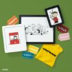 A flat lay of Peanuts-themed items: framed comic art, character name tags (Snoopy, Lucy, Charlie, Linus, Sally), a yellow shirt with a zigzag stripe, and two framed pictures featuring Peanuts characters on a green background.