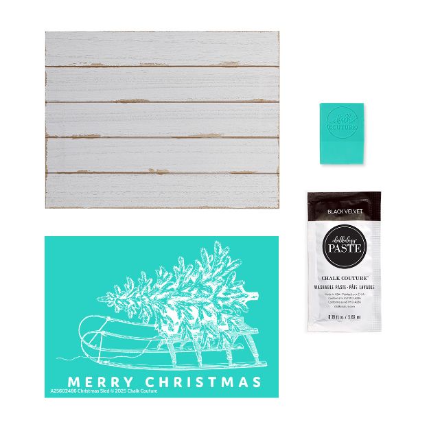 Flat lay showing a white wooden sign, a turquoise squeegee, a turquoise stencil with "Merry Christmas" and a sleigh, and a packet of black velvet chalk paste.