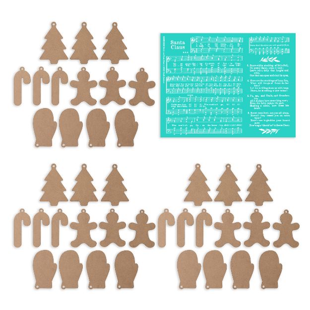 Assorted brown cardboard cutouts in shapes of candy canes, trees, mittens, and gingerbread people are arranged in groups. A turquoise sheet with "Santa Claus Is Coming to Town" lyrics and music is in the top right corner.