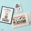 A framed Charlie Brown print reads “Not the best but still good!”, a notebook with Snoopy says “Be Nice.”, and a pouch with Peanuts characters says “My attitude is my favorite accessory.”.