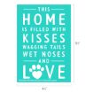 A teal sign with white text reads: "This home is filled with kisses, wagging tails, wet noses and love," with a paw print replacing the "O" in "LOVE." Dimensions are 6½" by 4½".
