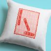 A white pillow with a pink word search design on it, forming the phrase “LOVE YOU MOST” in bold red letters diagonally and vertically on a light blue background.