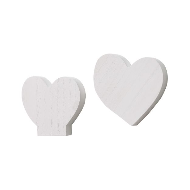 Two white wooden heart-shaped figures, one smaller with a flat base and one larger with a rounded base, placed against a plain white background.