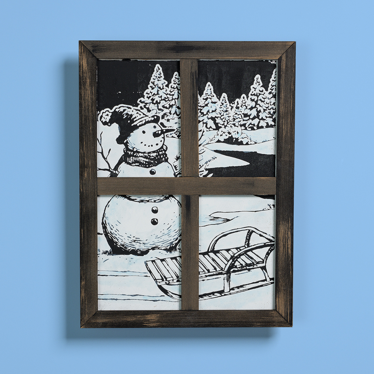 A framed illustration resembling a window shows a snowman with a hat and scarf, snowy trees, and a sled on the ground, all in black and white against a blue background.