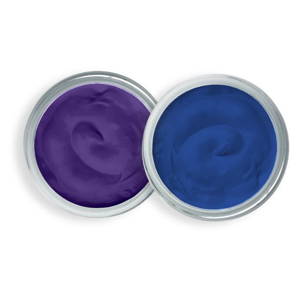 Two open containers of creamy pigment, one purple and one blue, positioned side by side with their lids off, viewed from above on a white background.
