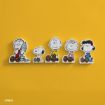 Cartoon cutouts of Peanuts characters—Linus, Snoopy, Charlie Brown, Sally, and Lucy—are lined up sitting against a bright yellow background.