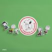 Stickers of Peanuts characters sit around a round sticker featuring Snoopy with the words "RAW STRENGTH & COURAGE" on a green background.