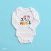 A white baby onesie with long sleeves, featuring a graphic of Snoopy hugging a pink heart above the colorful text "I HUGS" on a blue background.