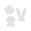 Three flat wooden shapes painted white: a chick head with tiny wings, a bunny head with long ears, and a lamb head. All shapes have a simple, minimalistic design.