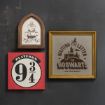 Three framed Harry Potter-themed signs on a wall: one says "Platform 9 3/4," another shows a Hogwarts crest, and the third has "Waiting on my letter to Hogwarts" with an owl and castle silhouette.