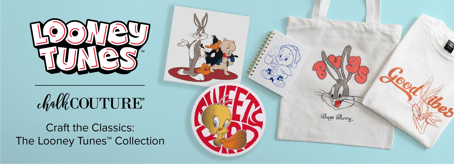 A display of Looney Tunes-themed merchandise, including a tote bag with Bugs Bunny, a t-shirt with "Good Vibes" and Daffy Duck, a Tweety Bird round sign, a Bugs Bunny and Daffy Duck print, and a notebook.