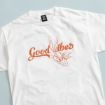White t-shirt with an orange outline drawing of Bugs Bunny making a peace sign, next to the words "Good Vibes" in bold, cursive orange letters.