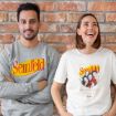 A man and a woman stand smiling against a brick wall, both wearing "Seinfeld" themed shirts. The man wears a gray sweatshirt and the woman a white T-shirt with a photo of the show's cast.