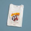 A folded white T-shirt featuring colorful "Seinfeld" text and graphic illustration of four characters from the TV show, with the tagline "A show about nothing" below. The T-shirt is set on a solid blue background.