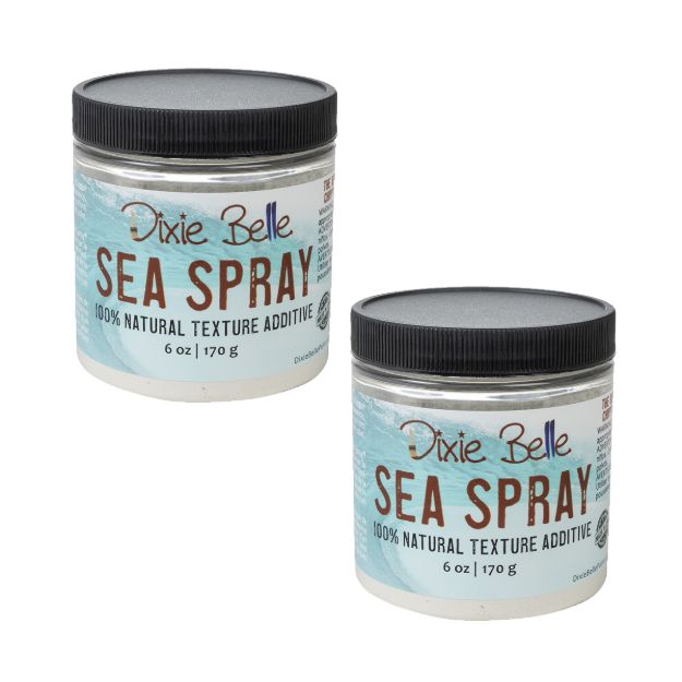 Two jars of Dixie Belle Sea Spray 100% Natural Texture Additive, each 6 oz (170 g), with light blue labels and black lids. The jars are placed side by side against a white background.