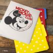 A binder with a vintage Mickey Mouse Club cover, featuring Mickey’s face and the words "Official Member," sits on a wooden surface with colorful polka dot file folders in red, blue, and yellow.