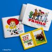 A flat lay displays Toy Story-themed items: a Jessie sketchbook, a pouch with Woody, Buzz, Jessie, Bullseye, and Aliens under the phrase “Family sticks together,” and a photo frame with “You’ve Got a Friend in Me” and a friends’ photo.