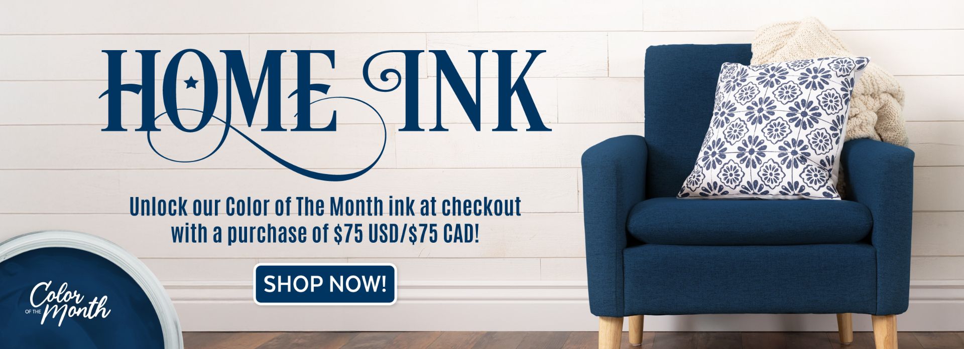 A cozy living room scene with a blue armchair featuring a white and blue patterned pillow, against a white wall and wooden floor. Text reads: "Home Ink. Unlock our Color of the Month ink at checkout with a purchase of $75 USD/$75 CAD! Shop Now!.