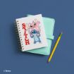 A white spiral notebook with Stitch and Angel cartoon characters and the word "STITCH" in red, beside a mint green planner and a yellow pencil on a blue surface.