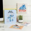 A desk with a “Best Friend” Stitch binder, Stitch wall art, a small potted plant, a Stitch notebook, a Stitch mouse pad, a keyboard, and a mouse. The theme is Disney’s Stitch.