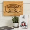 A wooden sign with a cartoon dog on a motorcycle and the text "Rad Dad Club" hangs above a small plant and a white notepad with a "Don't forget the snacks" sticker featuring the same dog.
